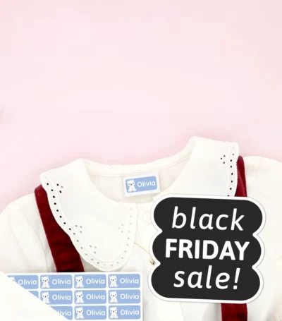 Children’s shoes and a dress with name labels attached, surrounded by snowflake decorations. Black Friday Sale.