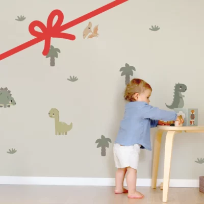 Small child playing in front of dinosaur and palm-themed wall decals in a kid’s room.