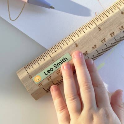Self-adhesive name labels on a ruler, perfect for personalizing school supplies. Ideal for children, these name tags feature playful designs and help prevent lost items. Enhance your child's organization with custom name labels that stand out.