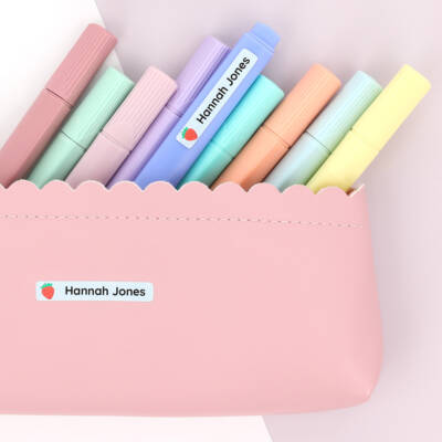 Personalized name label on a pink pencil case filled with colorful markers, ideal for children's school supplies. Perfect for organizing and adding a personal touch to kids' crafting items.