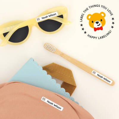 Personalized pencil name labels on children's sunglasses, a bamboo toothbrush, and a colorful backpack, showcasing practical and fun labeling solutions for kids' belongings.