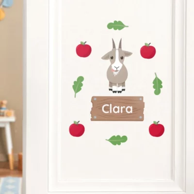 Personalized door sticker for children featuring a cute goat illustration surrounded by red apples and green leaves. Ideal for decorating kids' rooms and adding a playful touch to their space.