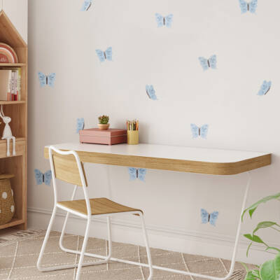 A bright children's room featuring a stylish desk and a wall adorned with decorative blue butterfly wall decals. The space is perfect for creative activities, emphasizing playful and inviting design for kids' decor.