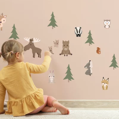 Child engaging with playful animal wall decals in soft colors, enhancing a cozy children's room atmosphere. Ideal for decorating nursery spaces and creating a whimsical environment with unique wall decor.