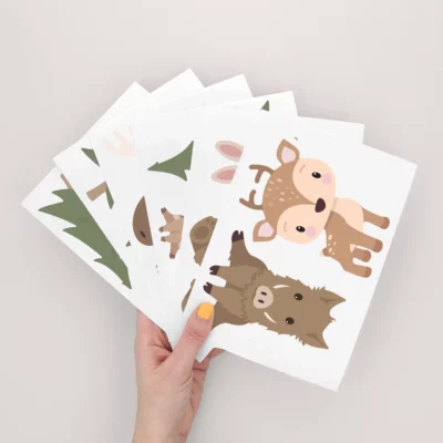 A hand holding a collection of cute animal illustrations featuring a deer, rabbit, and wild boar, perfect for children's room decor, wall art, or personalized birthday cards. Ideal for adding a whimsical touch to your child's space.